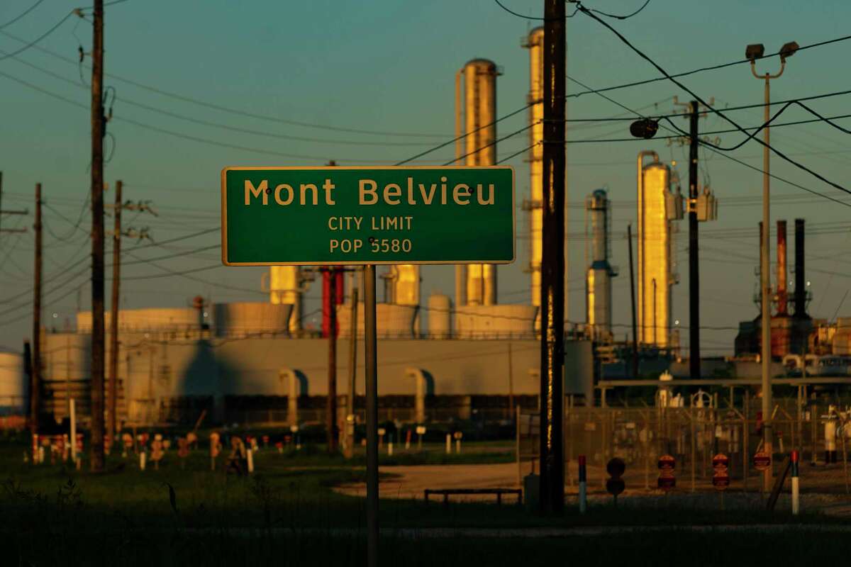 A city limit sign for Mont Belvieu is surrounded by heavy industry, where many facilities have received property tax breaks under the Chapter 313 program.