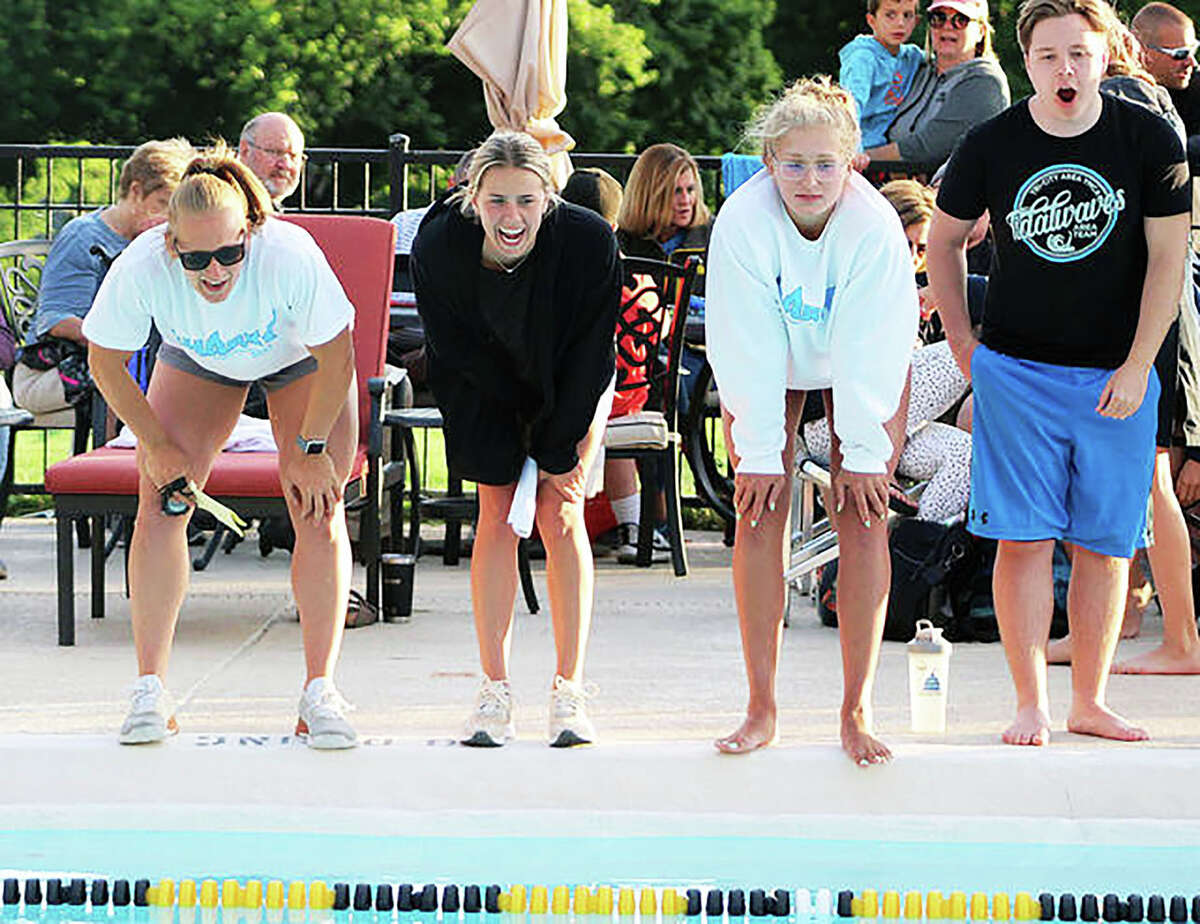 Summers Port head coach Maddie Monroe, far left, and assistant coaches Ginny Schranck, center and Anna Moehn shout encouragement to a Sharks swimmers during last year's SWISA Relays. Moehn is still an assistant coach, while Schranck is now living in North Carolina and has been replaced by Patrick Moehn on the coaching staff. This year's SWISA relays are set for Monday at Sunset Hills.