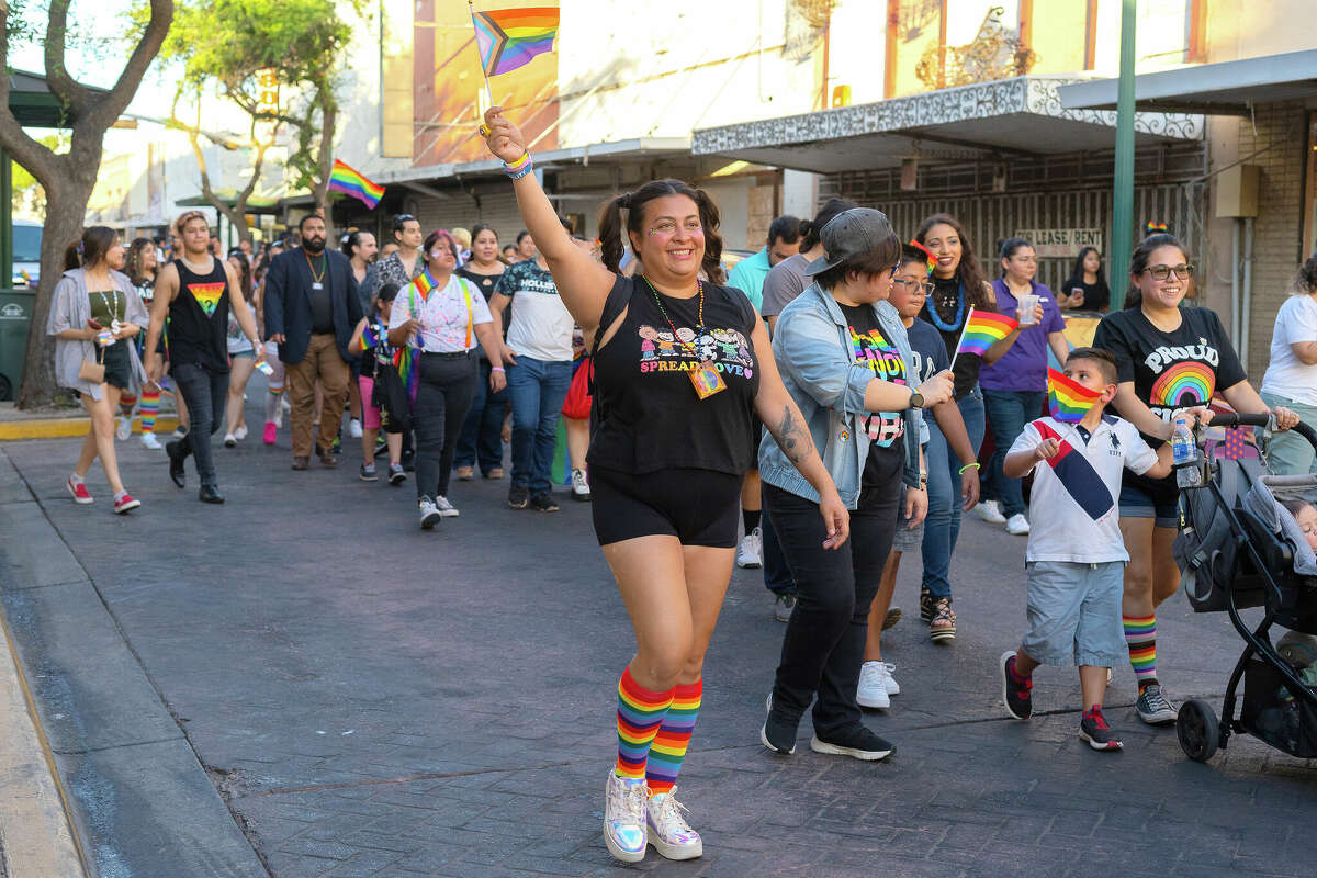 People wave their Pride flags as they march during the Gateway City Pride Parade & Festival on June 18.