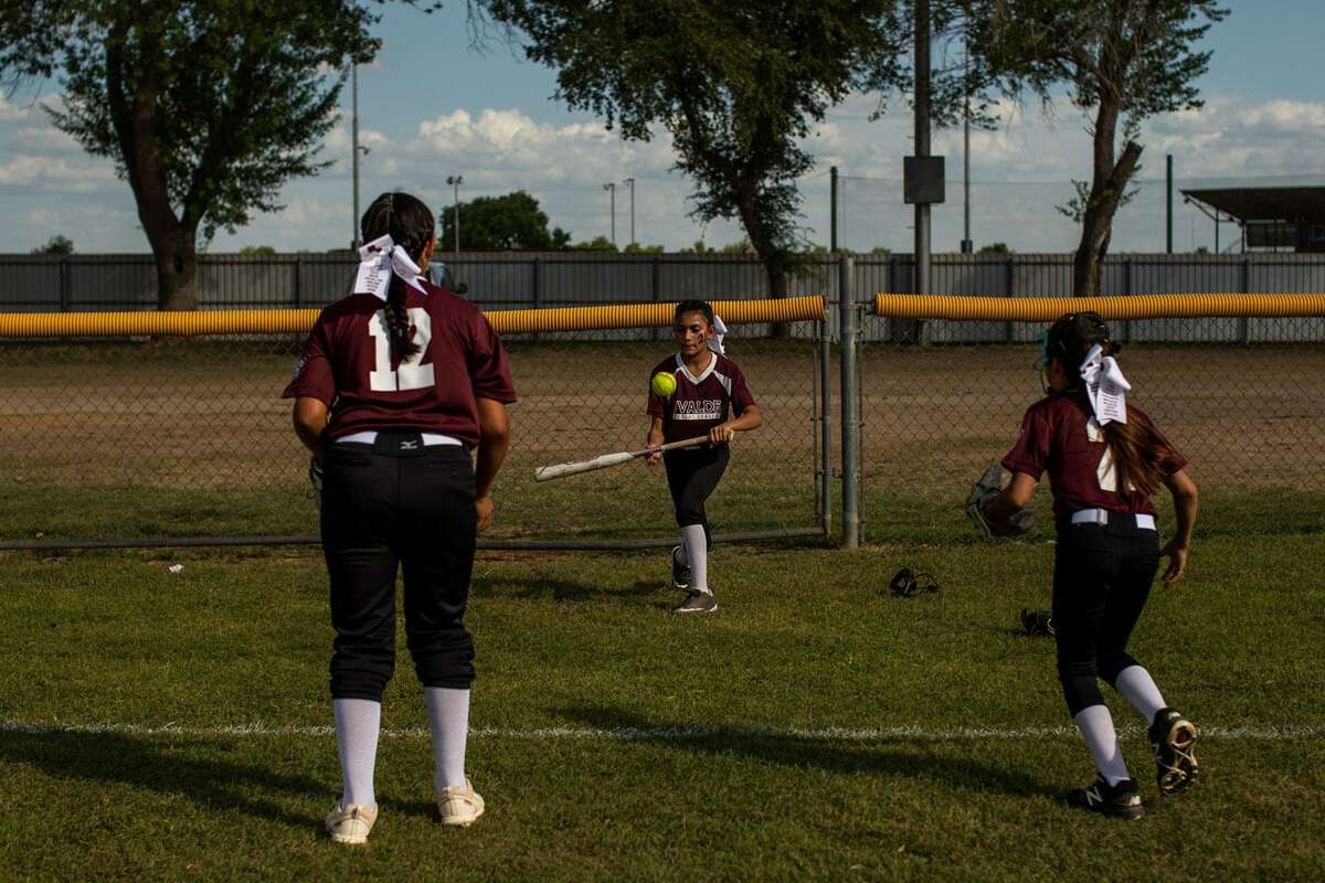 Uvalde minor league girls all-stars team members Maddison Galvan (12) and Utica Flores (2) warm up with another teammate ahead of their game in Uvalde on Saturday afternoon.