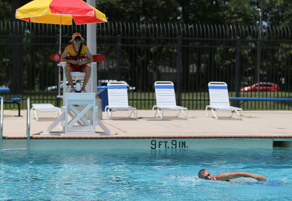 Joe Resendez swims past lifeguard Nico Garza, 20, at the Mason Park swim pool in Houston on Tuesday, June 7, 2022 as the city ushers in summer with dangerous heat. 