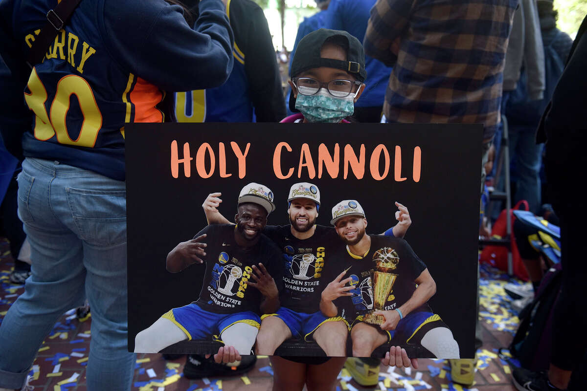 Jordan, from Hercules, shows off a homemade sign along Market Street, prior to the start of the Warriors victory parade, on Monday, June 20, 2022. 