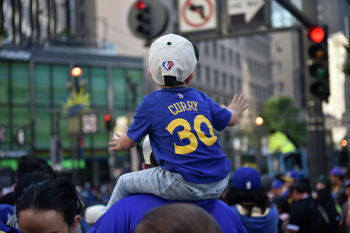 A young Warriors fan eagerly awaits the start of the Warriors victory parade along Market Street, on Monday June 20, 2022.