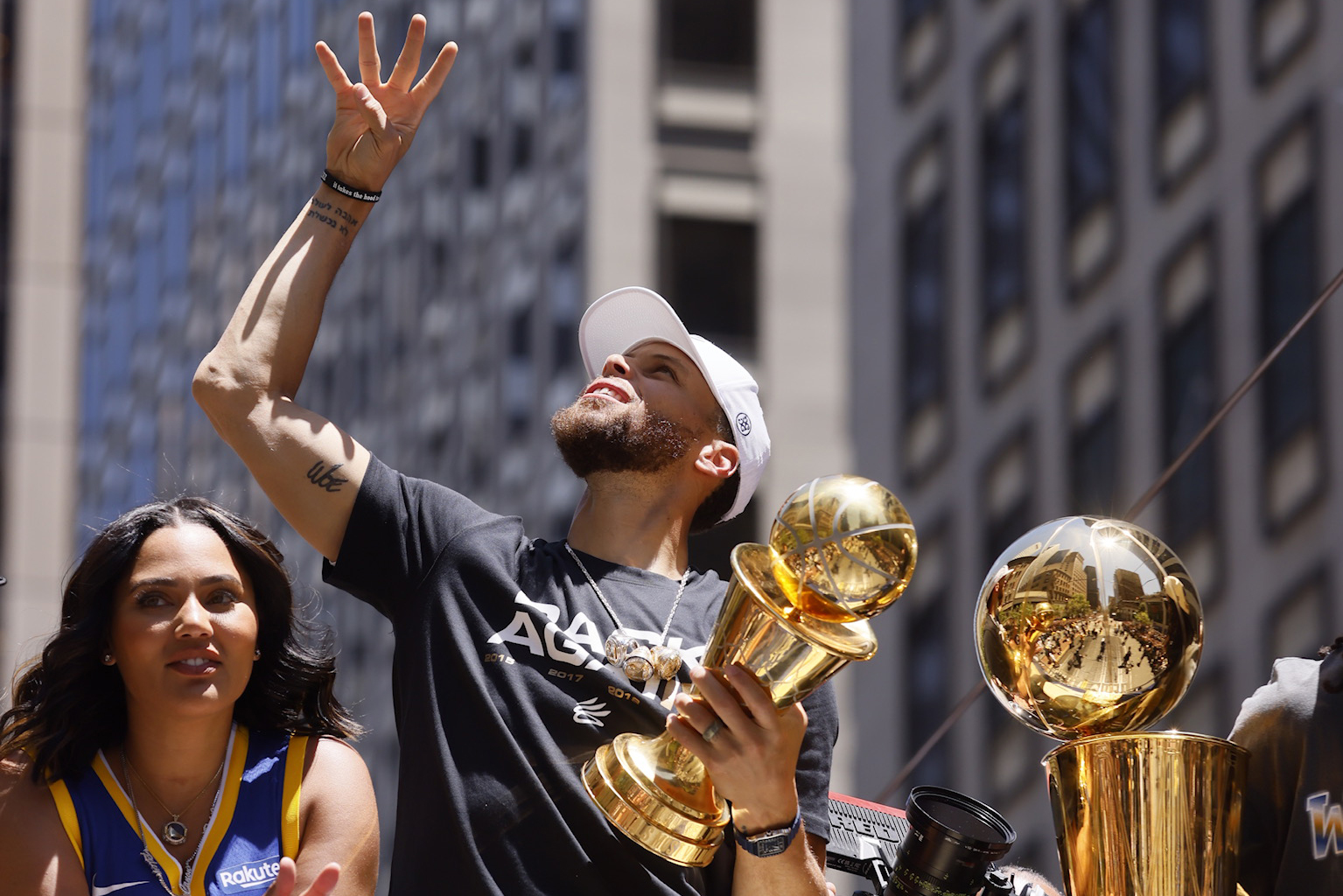 Golden State Warriors' Stephen Curry gestures while holding the Larry O'Brien  trophy during a parade and rally after winning the NBA basketball  championship, in Oakland, Calif. (AP Photo/Marcio Jo …