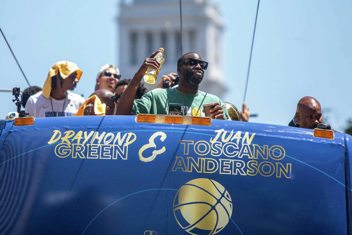 O atacante do Golden State Warriors, Draymond Green, segura uma garrafa de Lobos Tequila durante a exibição do Golden State Warriors Championship na Market Street, em San Francisco, Califórnia, em 20 de junho de 2022.