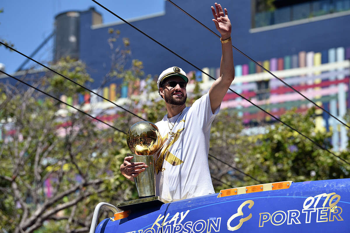 Klay Thompson waves from atop a bus during the Warriors victory parade on Market Street, on Monday June 20, 2022. 