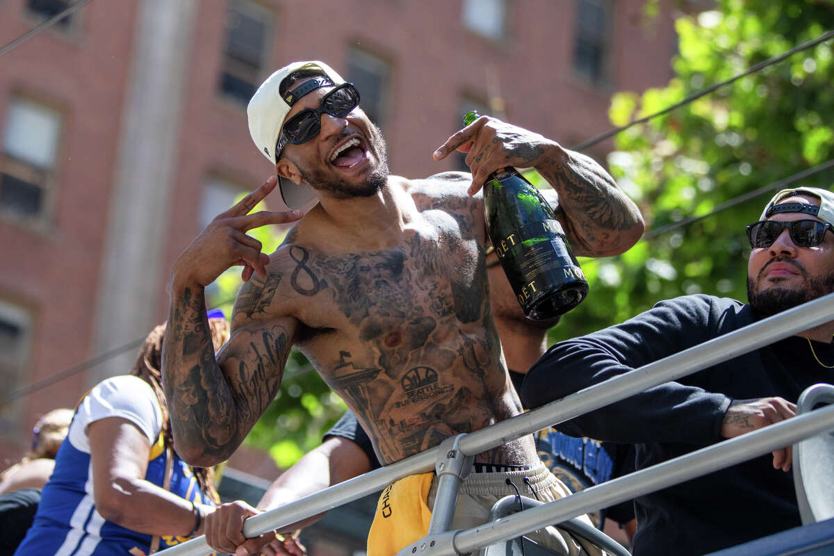 O atacante Gary Payton II posa para uma foto segurando uma garrafa de champanhe Moet durante o Golden State Warriors Championship Parade na Market Street em San Francisco, Califórnia, em 20 de junho de 2022.