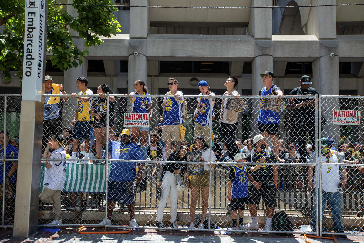 2022 年 6 月 20 日，在加利福尼亞州舊金山市集街舉行的金州勇士錦標賽遊行期間，球迷們站在欄杆上觀看比賽。