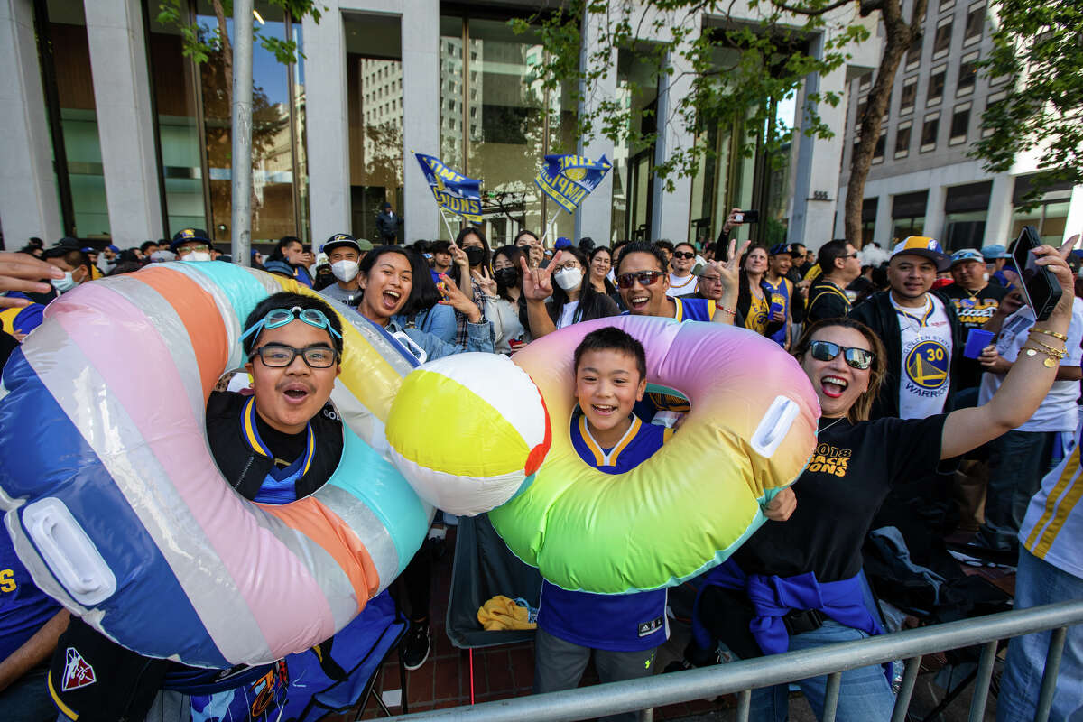 Un par de aficionados disfrutan de la "Fiesta en la piscina" durante el desfile del Campeonato Golden State Warriors en Market Street en San Francisco, California, el 20 de junio de 2022.