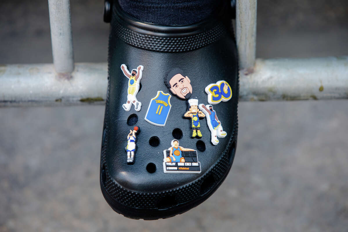 A fan wars crocs adorned with Klay Thompson stickers during the Golden State Warriors Championship Parade on Market Street in San Francisco, California on June 20, 2022.