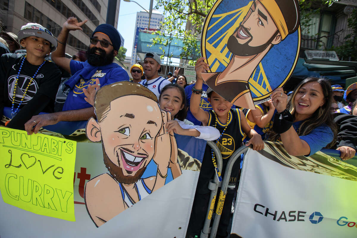 Fãs dos Warriors seguram faixas durante o Golden State Warriors Championship Parade na Market Street em San Francisco, Califórnia, em 20 de junho de 2022.
