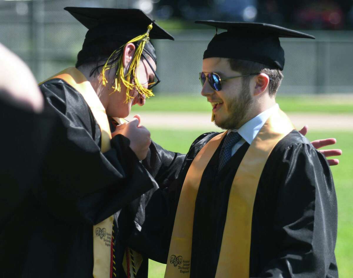 Graduating seniors Thomas Clarke, left, and Joseph Colangelo shake hands during the 2022 commencement ceremony at Academy of Information Technology & Engineering magnet high school in Stamford, Conn. Monday, June 20, 2022.