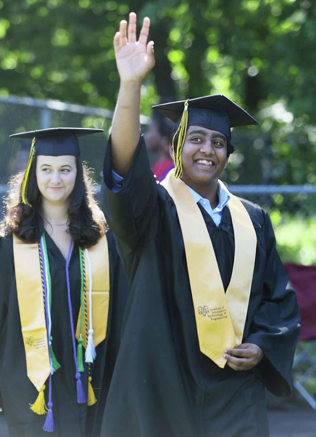 Graduating senior Devesh Singh waves to his family during the processional at the 2022 commencement ceremony at Academy of Information Technology & Engineering magnet high school in Stamford, Conn. Monday, June 20, 2022.