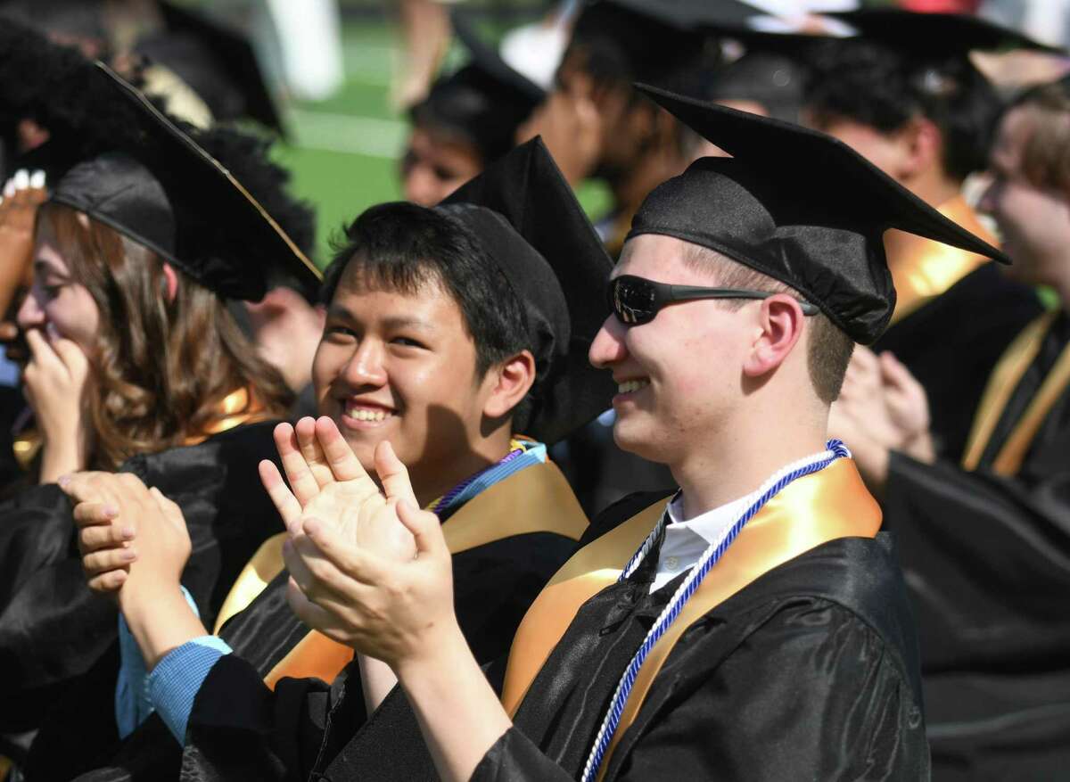 Graduating seniors Lance Uymatiao, left, and Nicholas Valenzano clap during the 2022 commencement ceremony at Academy of Information Technology & Engineering magnet high school in Stamford, Conn. Monday, June 20, 2022.