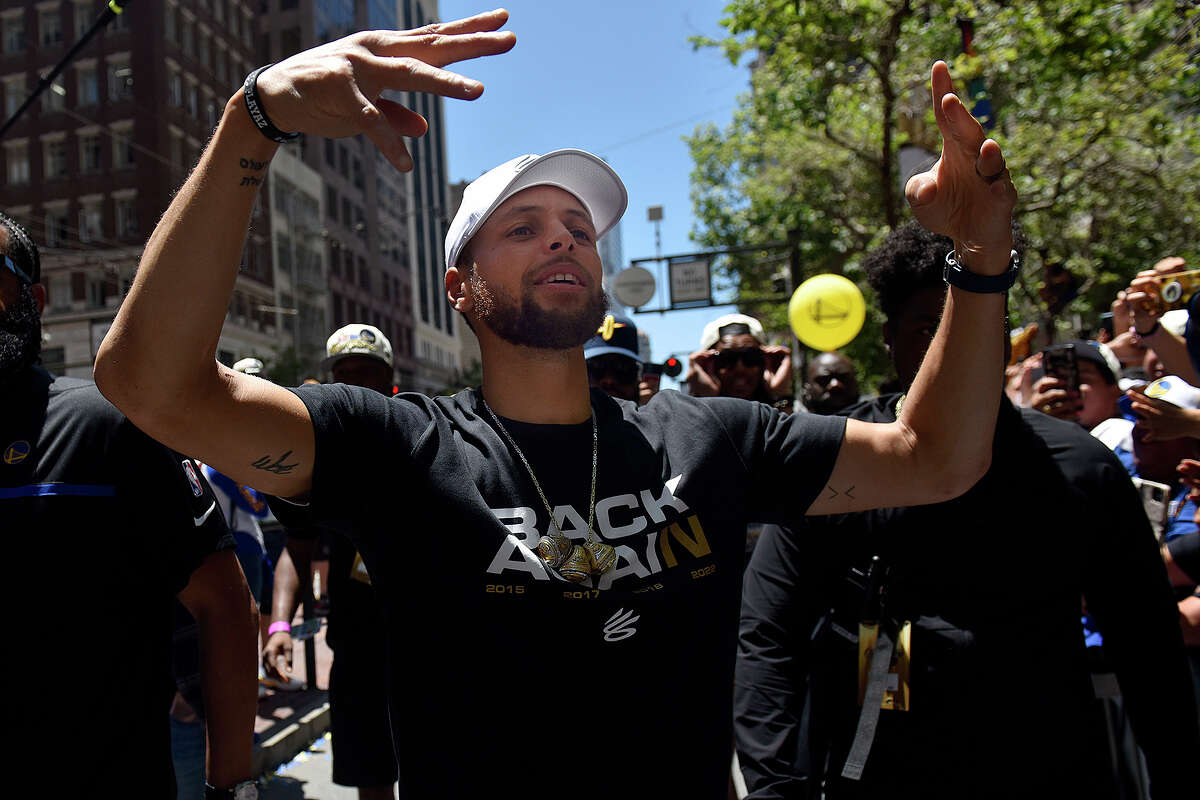 Stephen Curry leaves his bus during the Warriors victory parade to interact with fans on Market Street. 