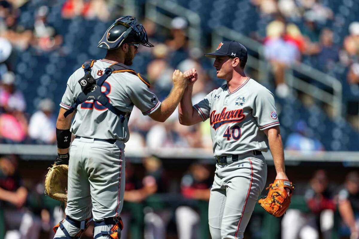 Auburn pitcher Blake Burkhalter (40) and catcher Nate LaRue (28) fist bump after the seventh inning against Stanford in an NCAA College World Series baseball game Monday, June 20, 2022, in Omaha, Neb. (AP Photo/John Peterson)
