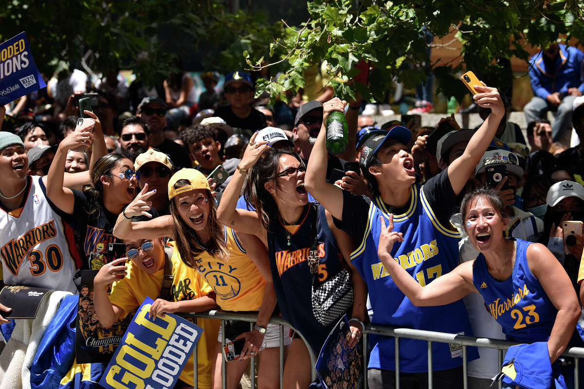 Warriors fans celebrate as head coach Steve Kerr passes them on Market Street. 