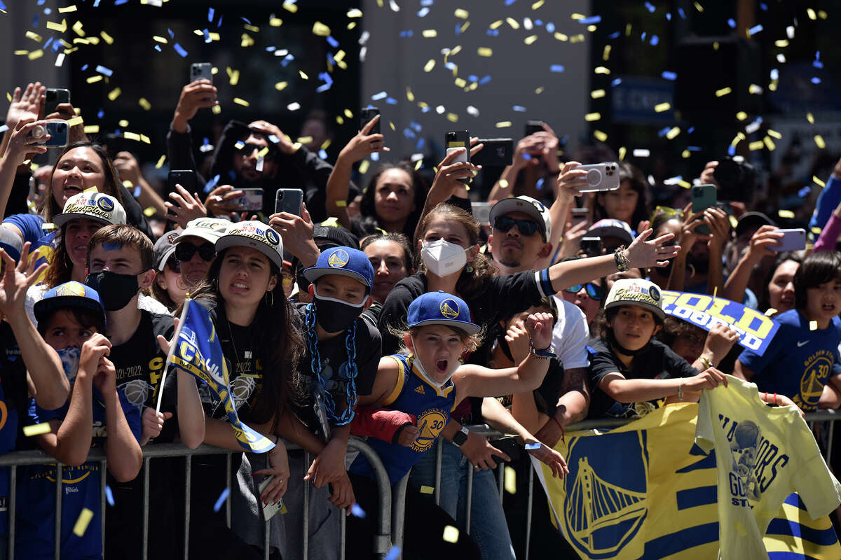 Fans react to Klay Thompson as his bus passes them during the Warriors victory parade on Market Street. 
