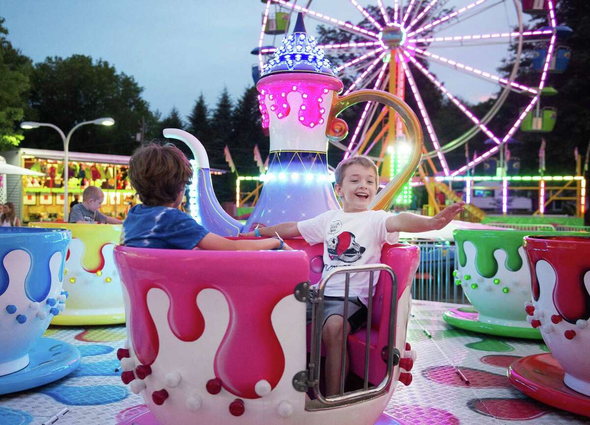Jack Moskwitz and James Semon ride the teacups at the annual Ridgefield Volunteer Fire Department carnival in 2019 at East Ridge School in Ridgefield, Conn. The carnival returns this week.