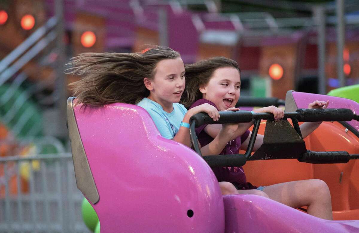 Twins, Ava and Cora Schardt ride the Swinger at the annual Ridgefield Volunteer Fire Department carnival in June 2019 at East Ridge School in Ridgefield, Conn. The carnival returns this week.