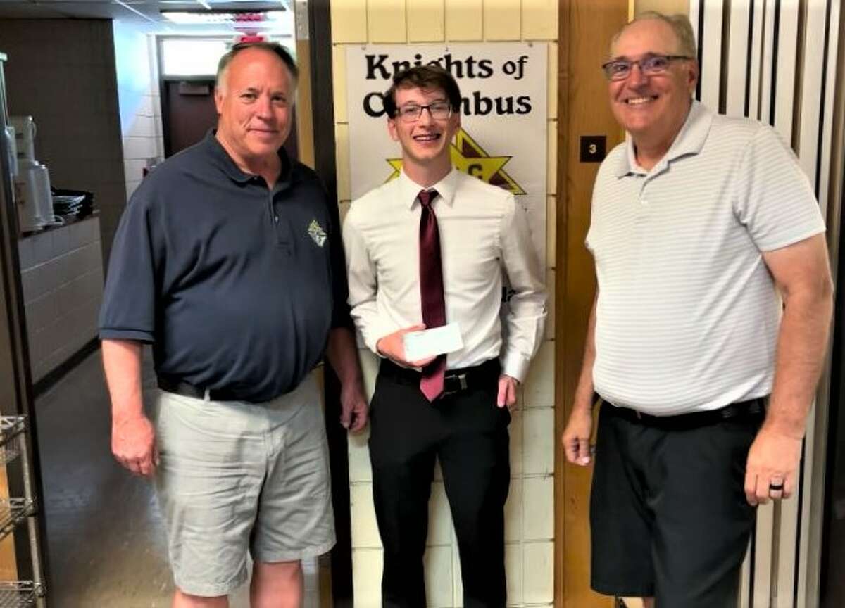 Manistee Catholic Central graduate Brendan McComb (center) accepts a $500 scholarship from Tim Kolanowski (left) and Michael Obranovich, of the Knights of Columbus. 