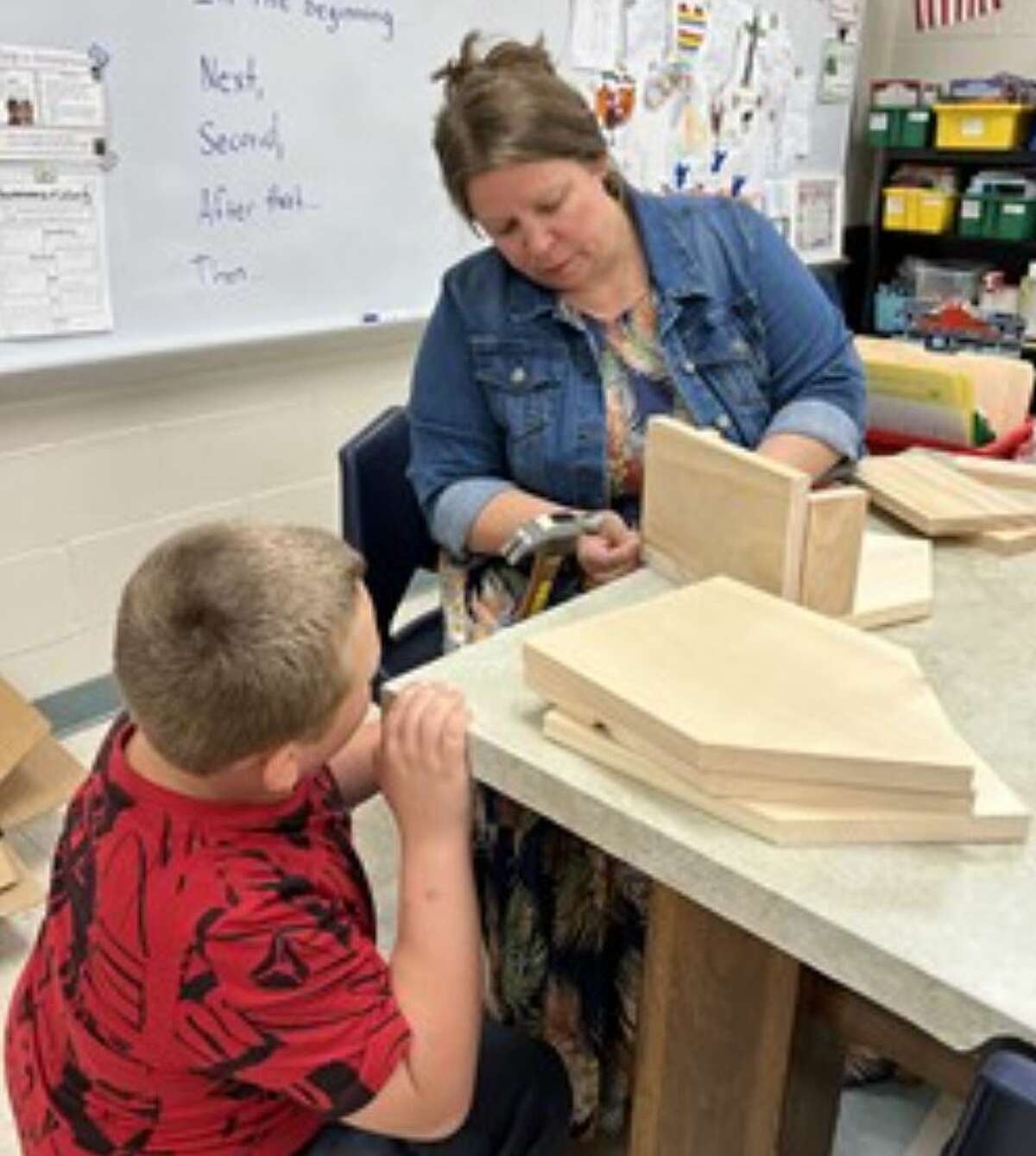 Mitchell teacher Allison Downing works with a student on creating birdhouses for Mitchell Elementary School.