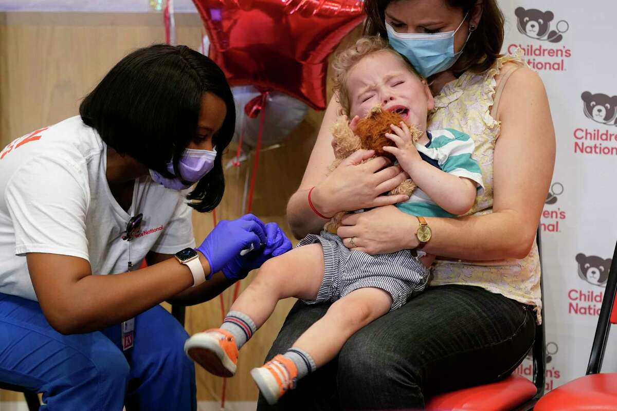 Leo Simon, age 2, reacts in the arms of his mother Brittany Head after registered nurse Reisa Lancaster administered a dose of a Pfizer COVID-19 vaccine at Children's National Hospital's research campus, Tuesday, June 21, 2022, in Washington. U.S. health officials have opened COVID-19 vaccines for infants, toddlers and preschoolers — the last group without the shots. (AP Photo/Patrick Semansky)