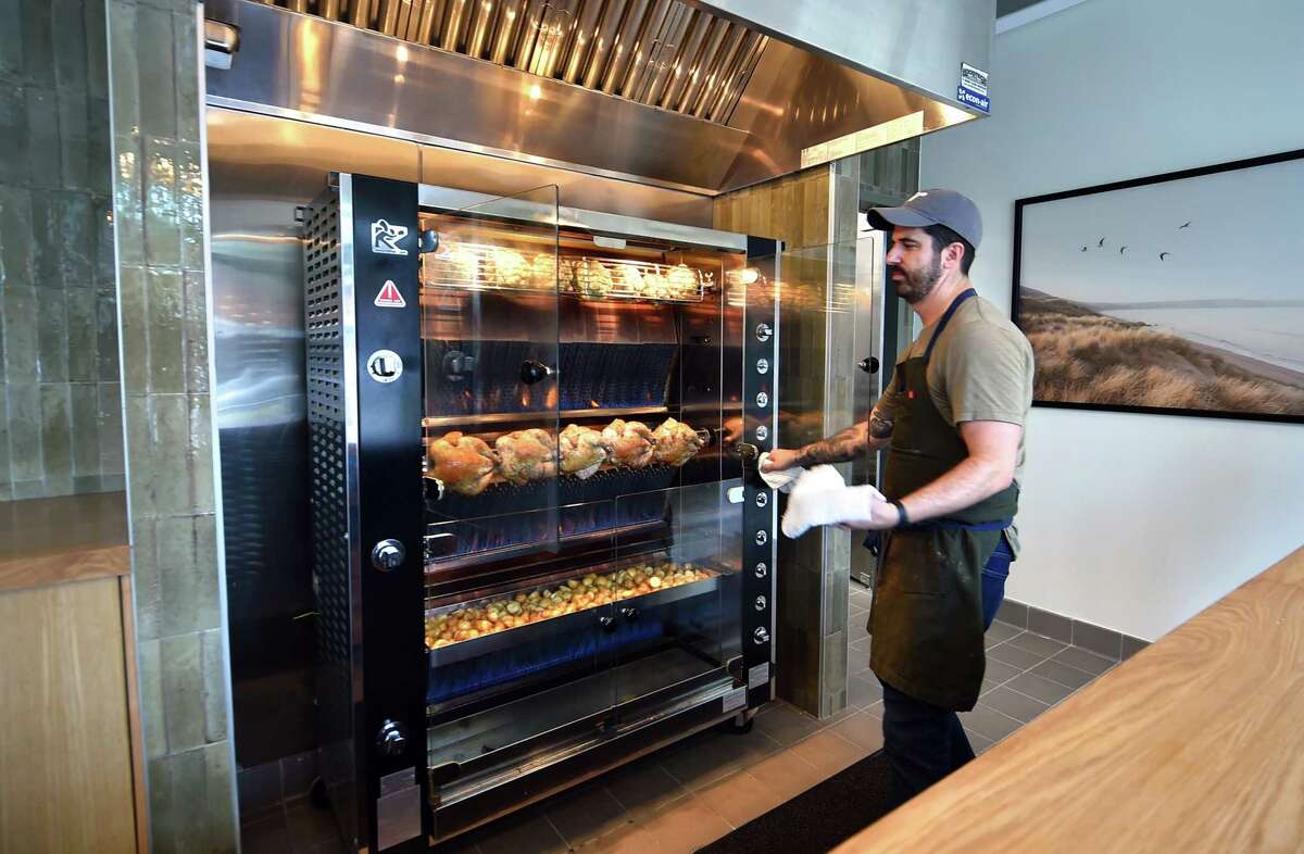 Owner Ben Pote checks on chickens cooking at the new restaurant Wildacre Rotisserie at 147 E Putnam Ave in Greenwich, Conn., on Tuesday June 21, 2022. Wildacre Rotisserie held a soft launch for friends and family in preparation for its official opening on June 23rd.
