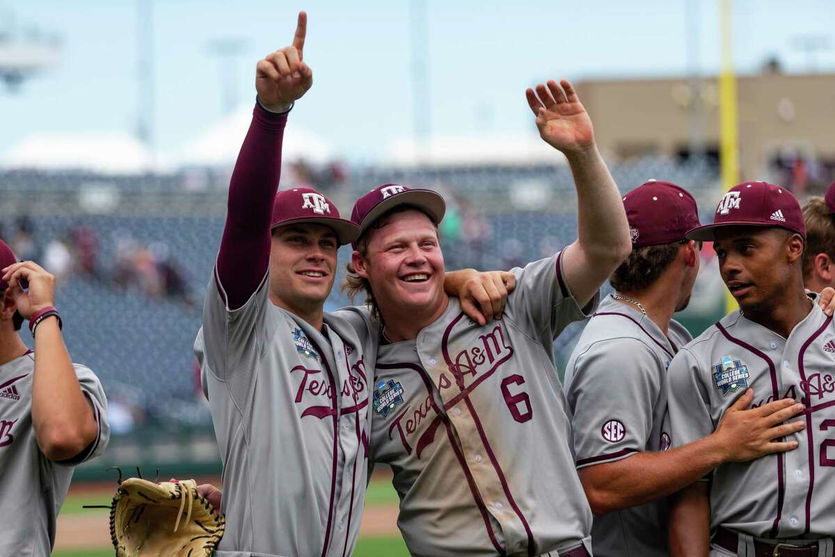Texas A&M Austin Bost (11) and Joseph Menefee (6) celebrate their win over Notre Dame during an NCAA College World Series baseball game Tuesday, June 21, 2022, in Omaha, Neb. (AP Photo/John Peterson)