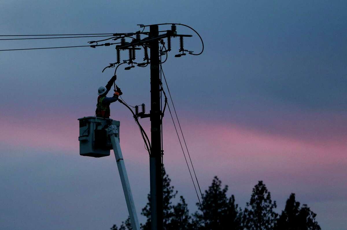 A Pacific Gas & Electric lineman works to repair a power line in Paradise (Butte County) in 2018. The utility is expanding its use of technology to detect faults on power lines that could cause wildfires, and shut the lines off.