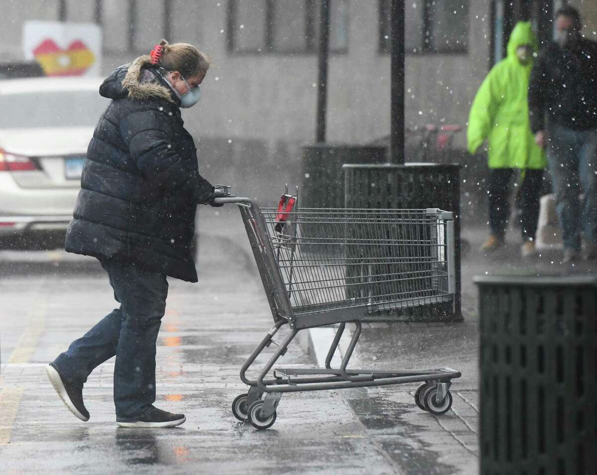 FILE PHOTO: A woman pushes her cart in the parking lot in the Riverside section of Greenwich, Conn. Rain is expected to continue in parts of Connecticut through Thursday, producing up to 1 inch of rainfall in some areas.