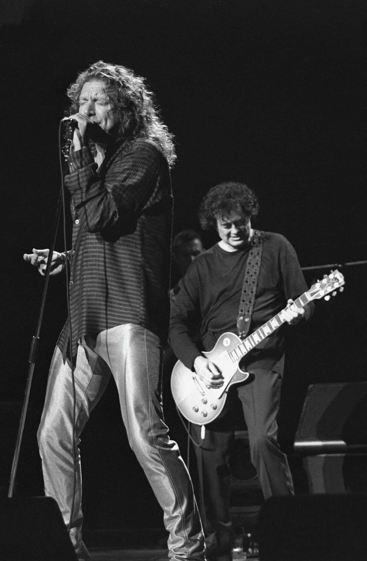 Singer Robert Plant and guitarist Jimmy Page are shown performing on stage during a concert appearance on October 21,1995 at the Hartford Civic Center. 