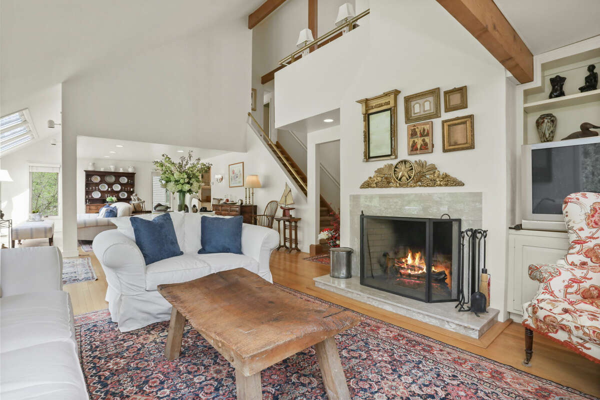 The open-plan great room has space for multiple seating areas, and it has one of the home’s two fireplaces.  