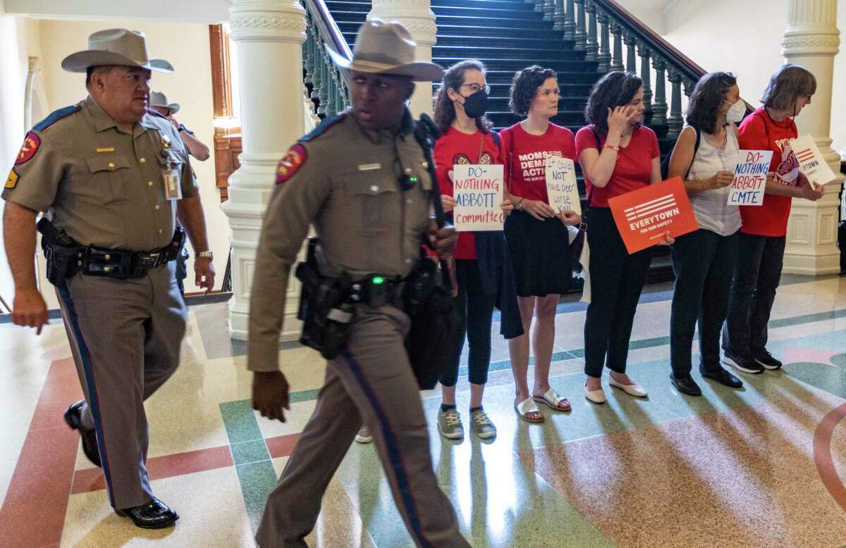 Members of Moms Demand Action hold signs Wednesday, June 22, 2022, outside the Senate chamber in the Capitol in Austin before the start of a meeting of the Senate Special Committee to Protect All Texans. The committee was convened in the wake of Uvalde’s Robb Elementary School shooting in which 19 children and two adults were killed by a teenager with an AR 15-style assault rifle.