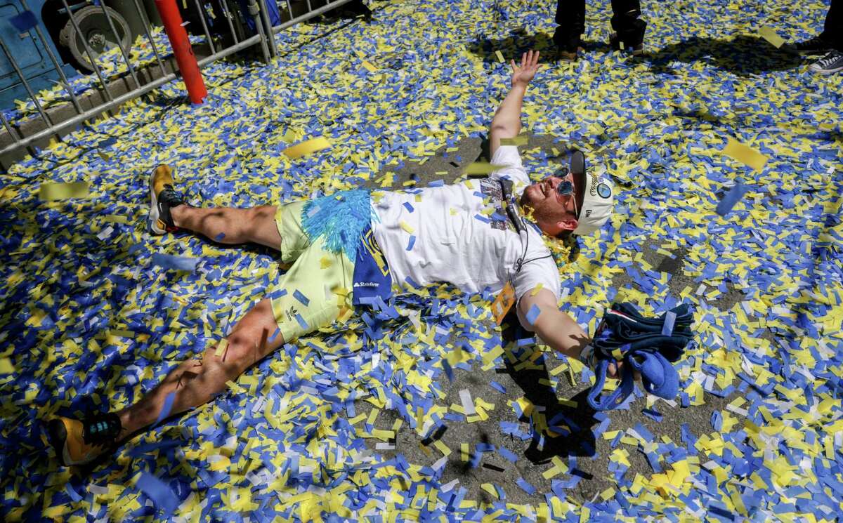 A fan rolls in confetti during the Warriors Championship parade in San Francisco, Calif., on Monday, June 20, 2022. San Francisco street sweepers and cleanup crews picked up around 38 tons — or about 76,000 pounds — of litter and debris following the parade.
