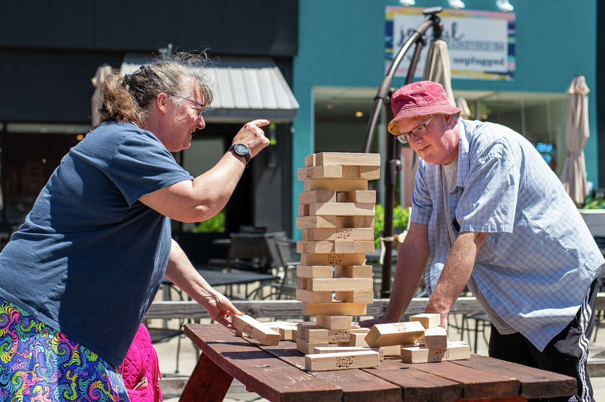Mount Pleasant residents Mary Vens (left) and Will Anderson play a game of Jenga on Wednesday, June 22, 2022 in Downtown Midland. The game was a part of the city's Adult Recess event series, which will be held from 11:30 a.m. - 1:30 p.m. every Wednesday through Aug. 31 in the Downtown Pedestrian Plaza.