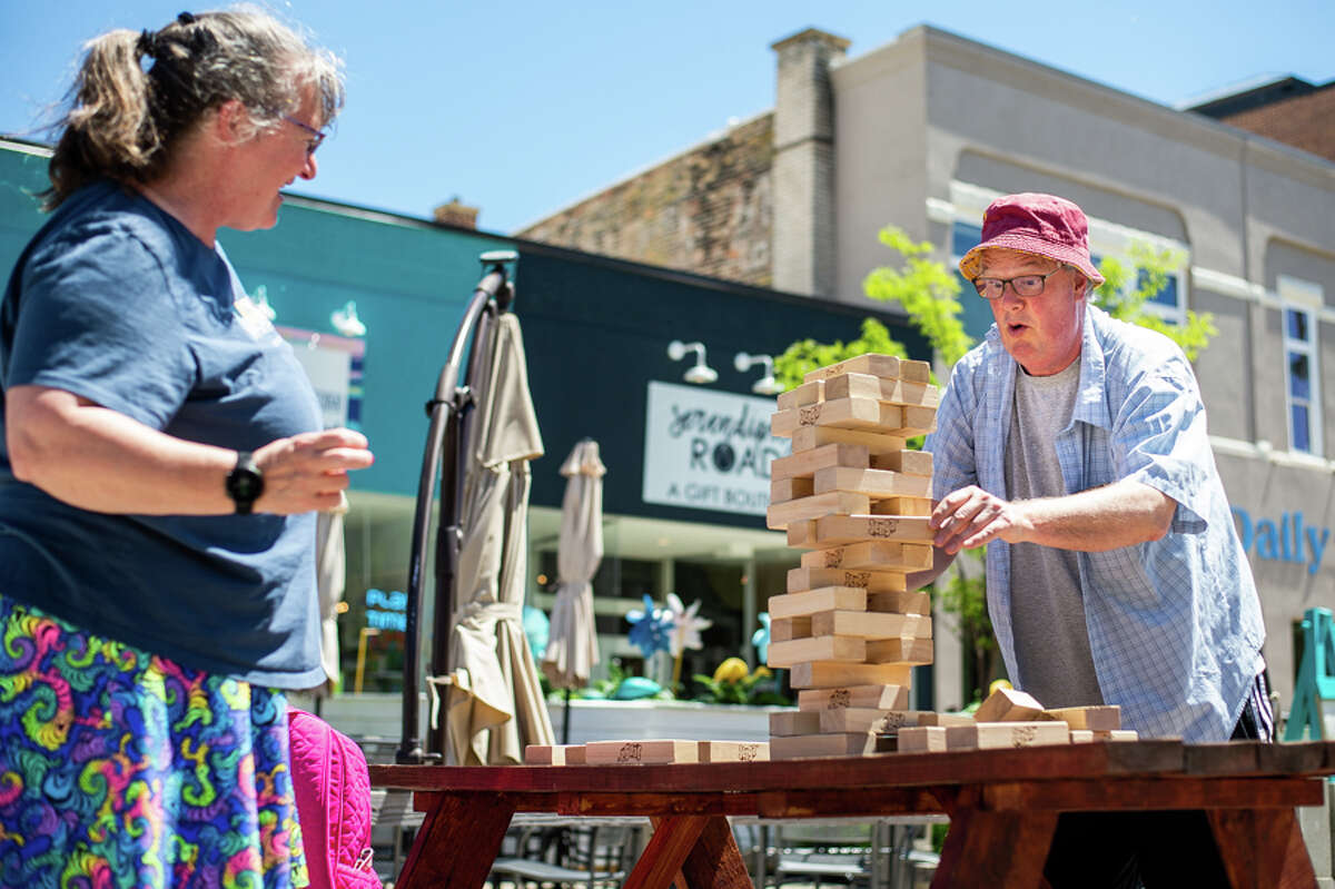 Mount Pleasant residents Mary Vens (left) and Will Anderson play a game of Jenga on Wednesday, June 22, 2022 in Downtown Midland. The game was a part of the city's Adult Recess event series, which will be held from 11:30 a.m. - 1:30 p.m. every Wednesday through Aug. 31 in the Downtown pedestrian Plaza.