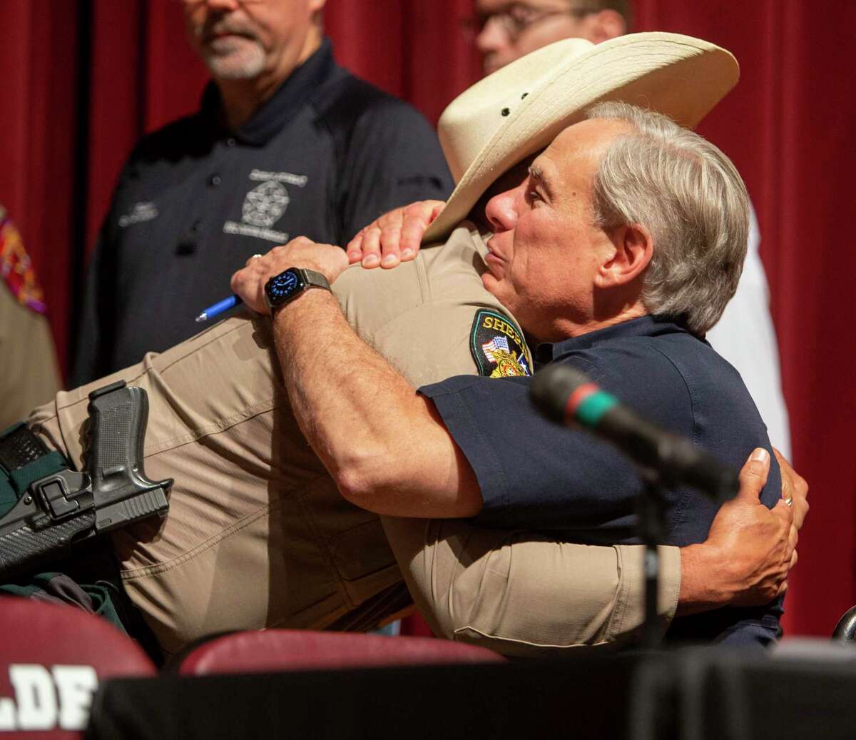 Uvalde County Sheriff Ruben Nolasco, left, hugs Gov. Greg Abbott Wednesday May 25, 2022 in Uvalde, Texas after the governor held a press conference to discuss the elementary school shooting that happened Tuesday. Authorities say Salvador Rolando Ramos, 18, opened fire Tuesday in a 4th grade classroom at Robb Elementary School killing 19 children and two teachers.