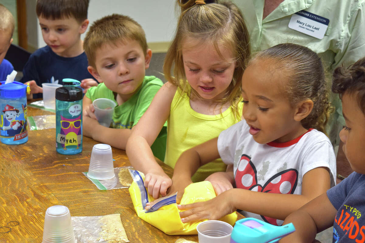 Arabella Howell (right), 5, and Myah Harney, 5, help create the base of a pumpkin pie mixture during a meeting of the Children's Community Garden Club. 