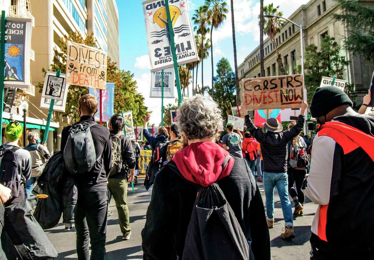 Climate activists rally in Sacramento in support of a bill to require California’s largest pension funds to divest from fossil fuels. The bill died this week after a Democratic lawmaker pulled it from a committee agenda.