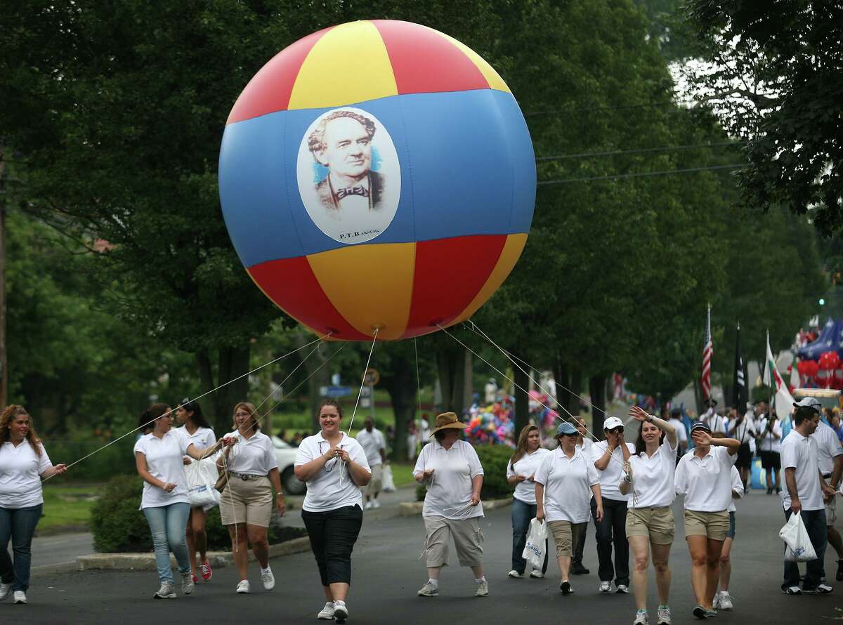 People's United Bank volunteers pull a helium balloon with the image of P.T. Barnum in the annual Barnum Festival Great Street Parade on Park Avenue in Bridgeport on Sunday, July 3, 2011.