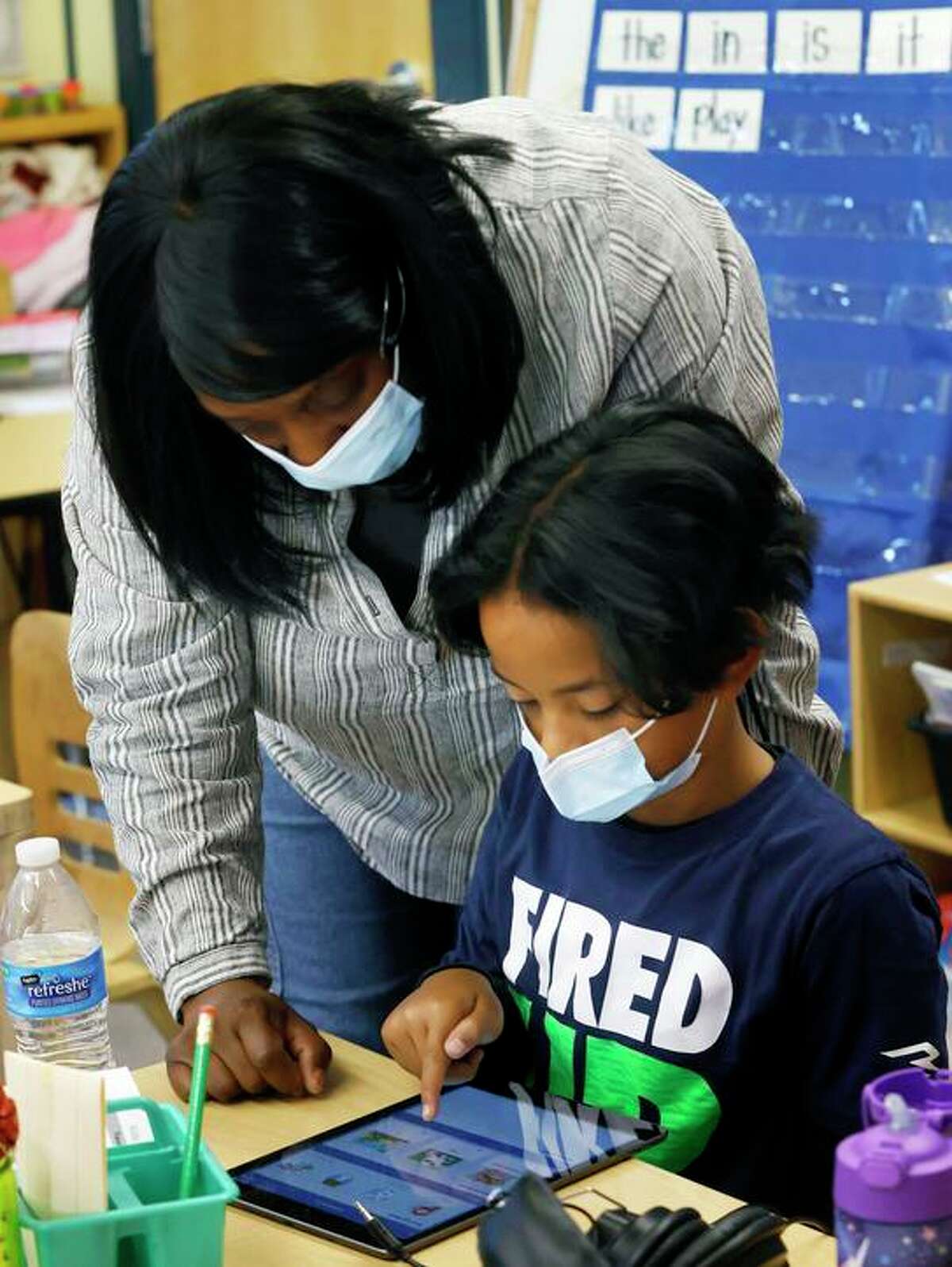 Kindergarten teacher Monique Williams helps Hesed Tauese during the Springboard summer reading program at Visitacion Valley Elementary School.