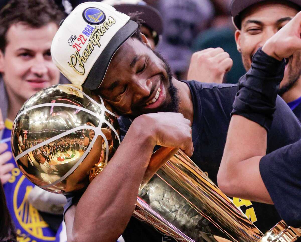 Golden State Warriors' Andrew Wiggins, 22, holds the Larry O’Brien Championship Trophy after Game 6 of the NBA Finals at TD Garden in Boston, Mass., on Thursday, June 16, 2022.
