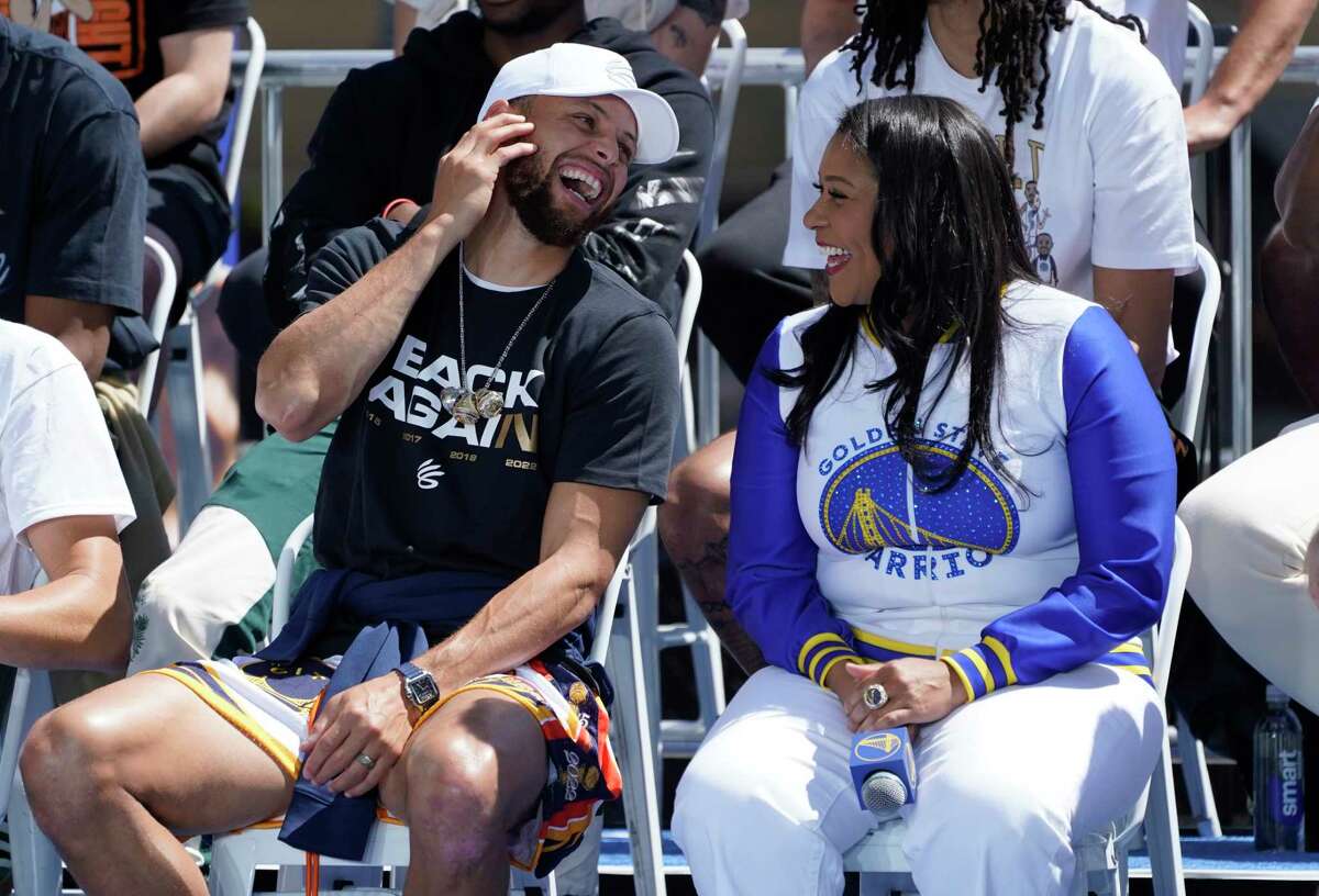 Golden State Warriors' Stephen Curry laughs with San Francisco Mayor London Breed on stage before the start of their NBA championship parade in San Francisco, Monday, June 20, 2022. (AP Photo/Eric Risberg)