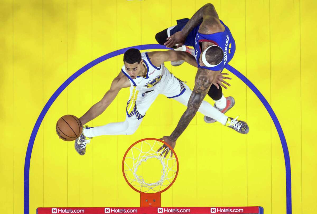 Jordan Poole (3) gets to the basket around DeMarcus Cousins (4) as the Golden State Warriors played the Denver Nuggets in game 2 of the NBA Playoffs first round at Chase Center in San Francisco, Calif., on Monday, April 18, 2022. The Warriors won 126-106.