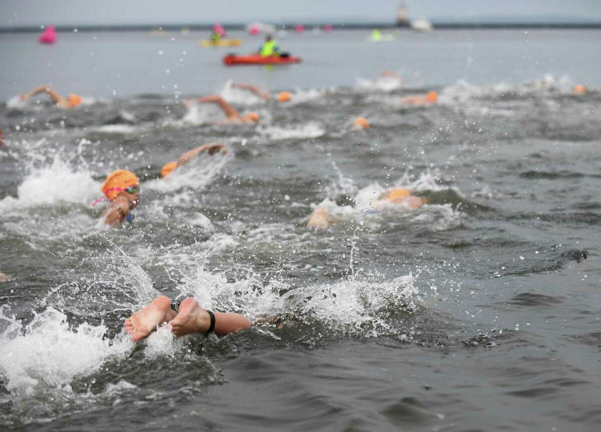 Swimmers take to the water at the Swim Across America Fairfield County event at Cummings Point in Stamford, Conn. Sunday, Aug. 8, 2021. More than $360,000 was raised at the event for the Alliance for Cancer Gene Therapy, a local nonprofit that funds research in cell and gene therapies to treat cancer. Swimmers swam routes ranging from half a mile to three miles as hundreds cheered them on from the shore.