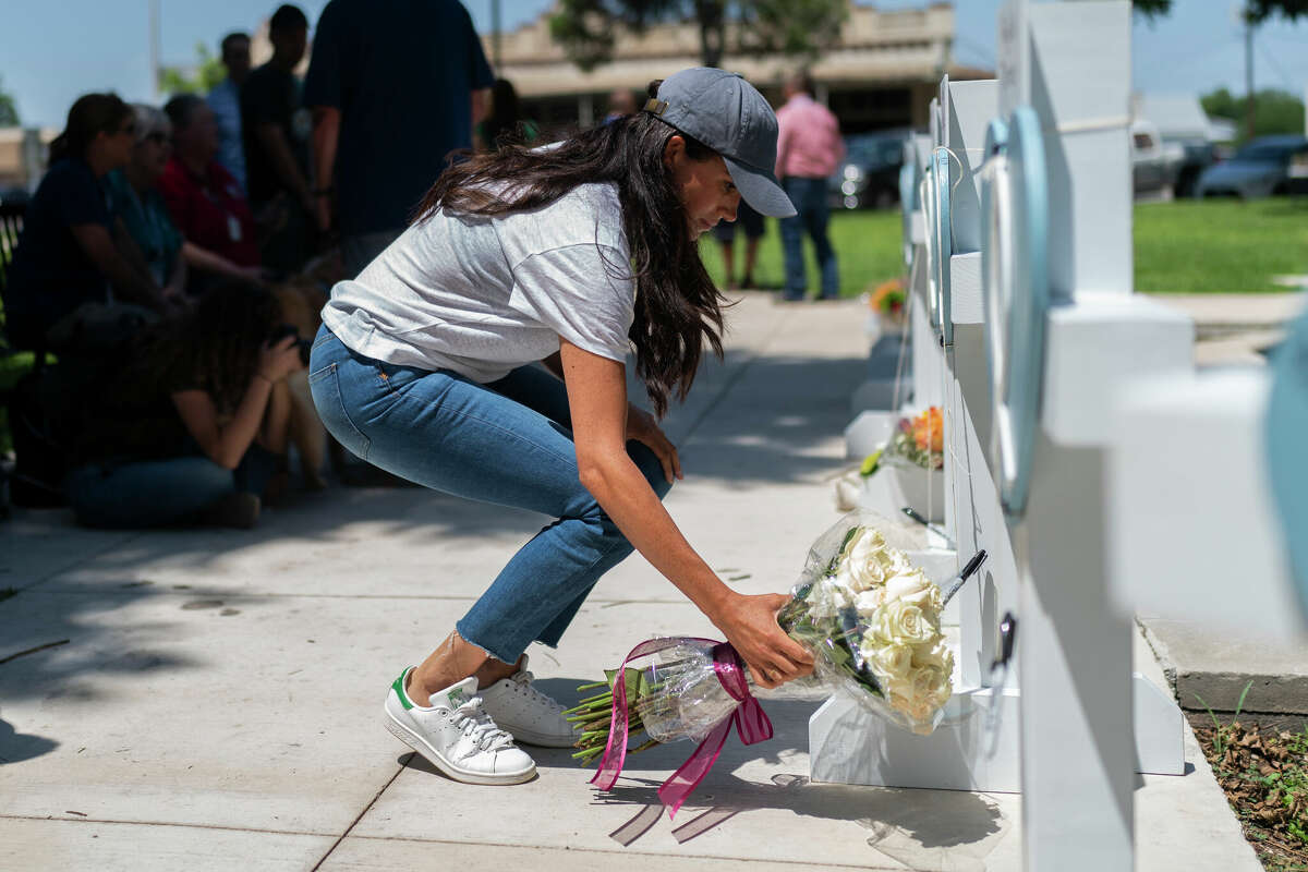 Meghan Markle, Duchess of Sussex, leaves flowers at a memorial site, Thursday, May 26, 2022, for the victims killed in this week's elementary school shooting in Uvalde, Texas. (AP Photo/Jae C. Hong)