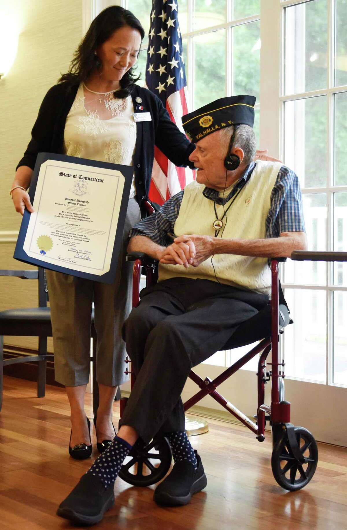 State Rep. Kimberly Fiorello presents U.S. Army Cpl. Edmund Burke with an official citation from the Connecticut General Assembly during a ceremony honoring his service at Parsonage Cottage in Greenwich, Conn. Wednesday, June 22, 2022. Burke was honored for his service and heroism as a machine gunner in World War II in a special ceremony Wednesday.