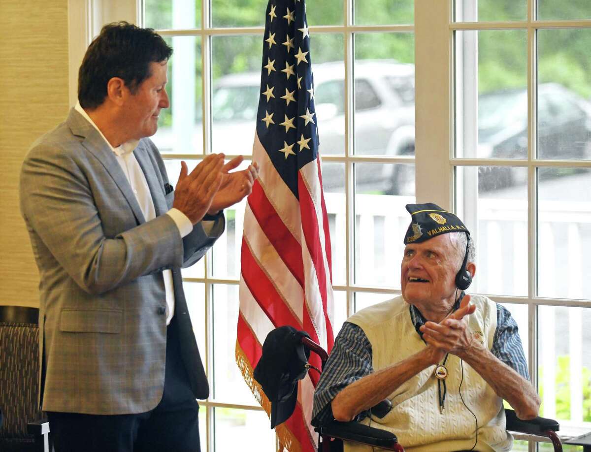 Bob Burke, left, speaks during a special ceremony honoring his father, U.S. Army Cpl. Edmund Burke, at Parsonage Cottage in Greenwich, Conn. Wednesday, June 22, 2022. Burke was presented with an official citation from the Connecticut General Assembly for his service and heroism as a machine gunner in World War II.