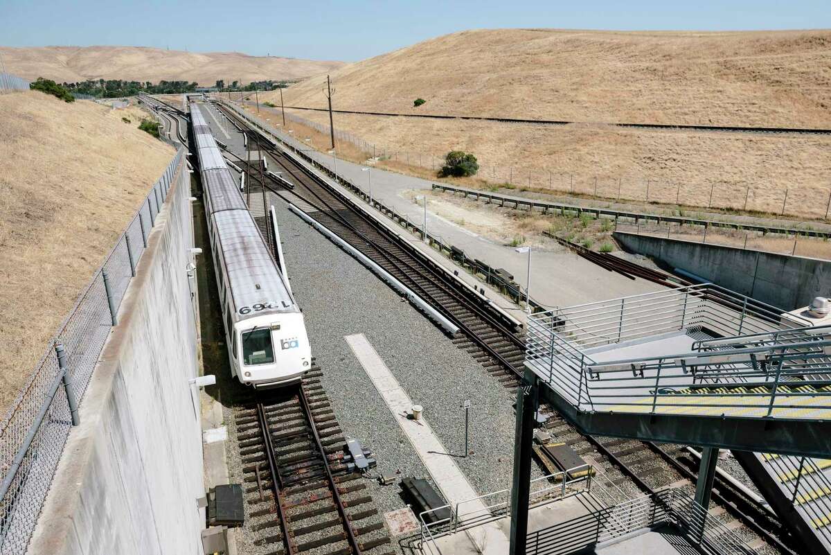 A train makes it’s way into the North Concord station, next to the Concord Naval Weapons Station, at right, in Concord, Calif., in 2019.